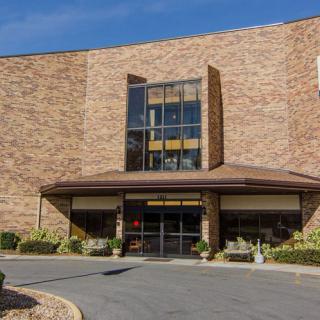 A brick commercial building with a prominent entrance and large glass windows.