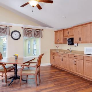 A cozy kitchen with wooden cabinets, a dining table set, and modern amenities.