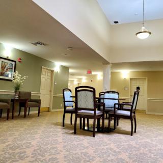 A cozy, well-lit room with a table and chairs, featuring tasteful decor and carpeting.