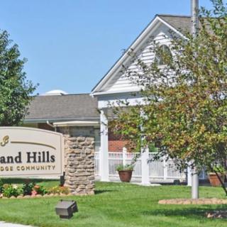 A suburban house with a sign reading 'Deerwood Hills' set in a landscaped front yard.