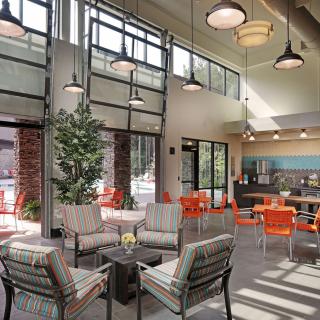 A modern lounge area featuring contemporary furniture, large windows, and stylish lighting.