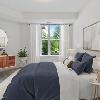 A modern bedroom with stylish decor, featuring a large bed and abundant natural light.