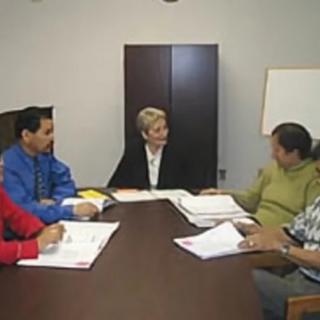 A group of people having a business meeting in an office setting.