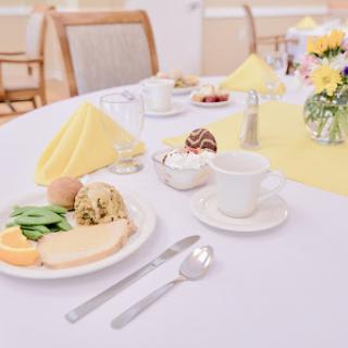 A beautifully arranged breakfast table with an assortment of food and fresh flowers.