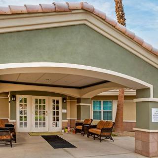 A modern building entrance with patio seating.