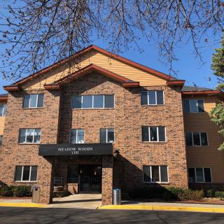 A brick residential apartment building with a prominent entrance.