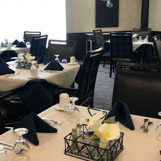 An elegantly set dining area with neatly arranged tables and chairs.