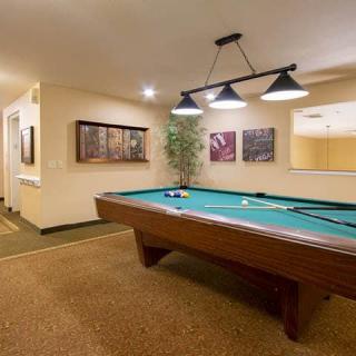 A cozy game room featuring a pool table and ambient lighting.