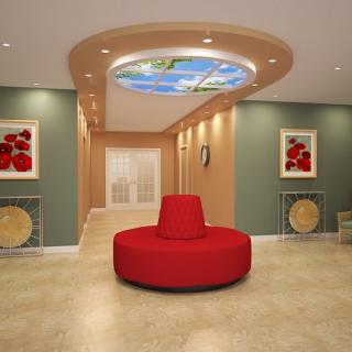 A modern lobby with a central red sofa and a decorative ceiling mural.
