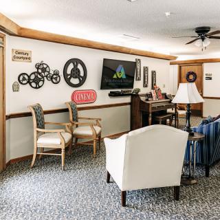 A cozy living room with comfortable seating, wall decorations, and a television.