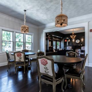 A beautifully designed dining room featuring elegant furniture and chandelier lighting.