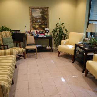 A cozy waiting room with comfortable seating and decorative plants.