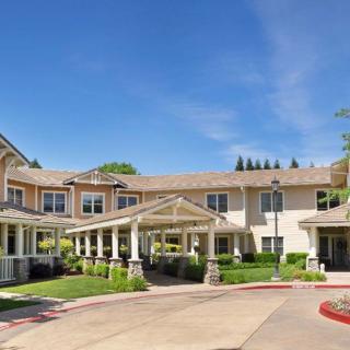 A two-story residential building with a landscaped yard and entrance.