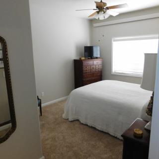 A neatly arranged bedroom with a bed, dresser, and window.
