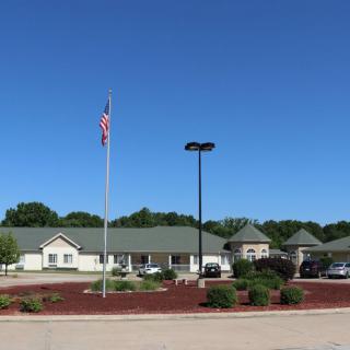 A building with a parking lot and an American flag on a clear day.