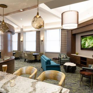 A modern lounge area featuring comfortable seating, stylish lighting, and a television.