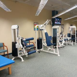 A well-equipped gym featuring various exercise machines for fitness and rehabilitation.