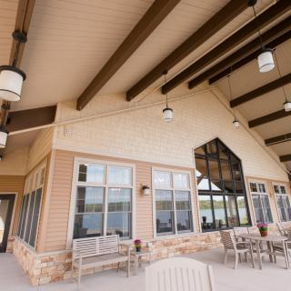 A modern patio area with seating and exposed wooden beams.