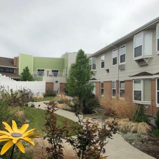 A residential apartment complex with a landscaped courtyard and garden path.