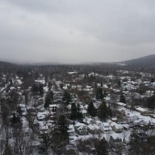 A serene winter landscape showcasing a town blanketed in snow under an overcast sky.