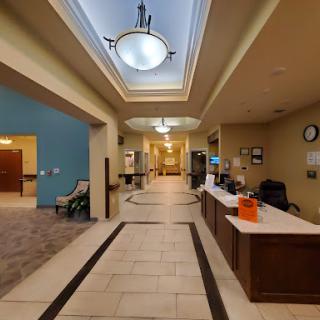 A modern lobby featuring a reception desk, elegant lighting, and a spacious hallway.