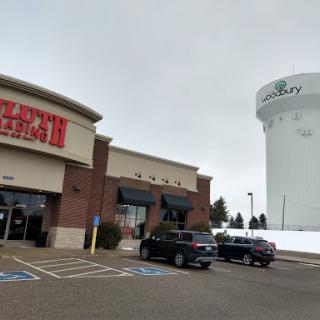 A restaurant with a water tower in the background on a cloudy day.