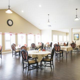 A bright and spacious dining room with elegantly set tables and chairs.