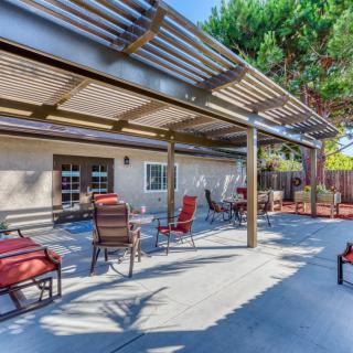 A spacious outdoor patio with seating under a pergola.