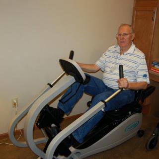 An elderly man using a specialized fitness machine for exercise.