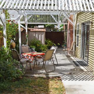 A cozy backyard patio with a pergola and outdoor seating area.