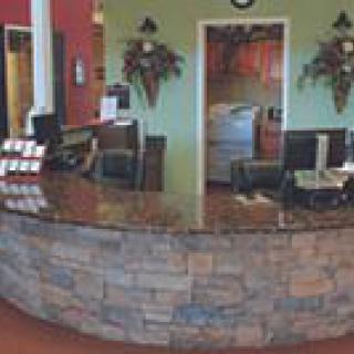 A reception desk with computer equipment and decorative elements in an office setting.