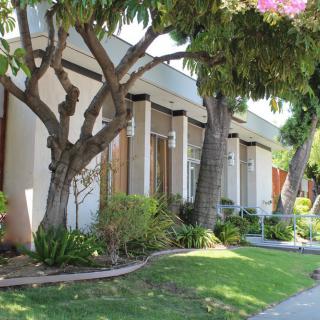 A residential house with a well-maintained garden and trees.