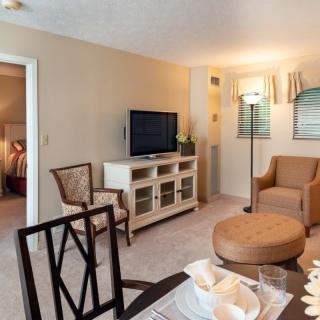 A cozy living room with comfortable seating, a TV, and a dining area.