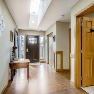 Bright hallway with wooden floors and a skylight illuminating the space.