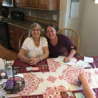 Two people sitting together at a kitchen table, enjoying each other's company.