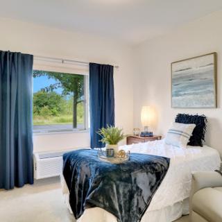 A cozy and modern bedroom featuring a serene view through the window.