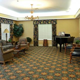 A cozy living room featuring a grand piano, comfortable seating, and decorative plants.