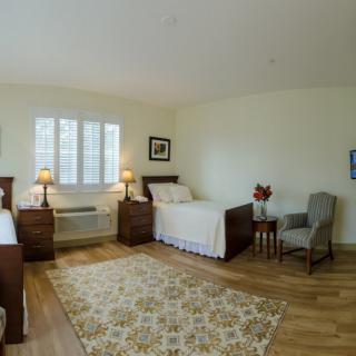 A spacious bedroom with twin beds, featuring cozy decor and ample natural light.