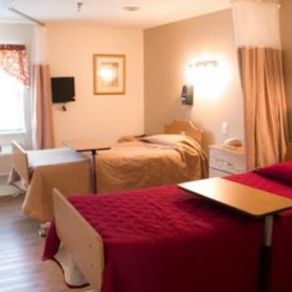 A hospital room with two beds and medical equipment.