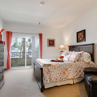 A cozy bedroom with elegant decor and a balcony view.