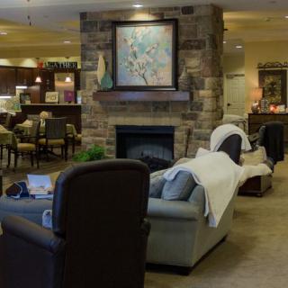 A cozy lobby seating area featuring a fireplace and artwork.