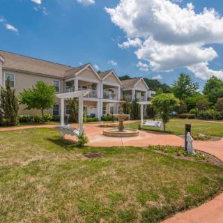 A scenic view of a building with a well-maintained garden and blue sky.