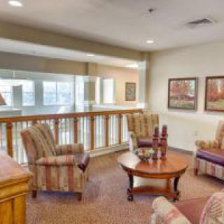 A cozy living room area featuring comfortable armchairs, a wooden coffee table, and decorative artwork on the walls.
