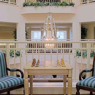 A chess table set up in a spacious, elegantly decorated lobby area.