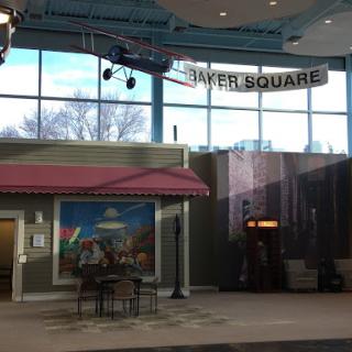 A view of a welcoming indoor public space with seating, decorative artwork, and signage.