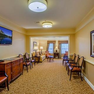 A warm and inviting seating area with multiple chairs and tables, featuring elegant interior design and soft lighting.