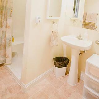 A clean and organized bathroom with a shower, sink, and mirror.