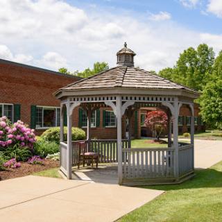 A charming gazebo surrounded by lush greenery and blooming flowers.