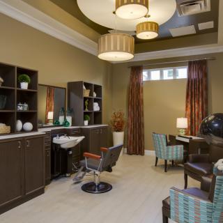 A modern salon interior with stylish furniture and warm lighting.