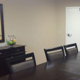 A neatly arranged dining room with a table, chairs, and a decorative vase.